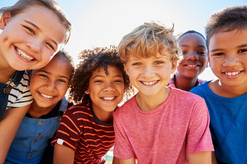 Sechs Primarschul-Kinder lachen in die Kamera