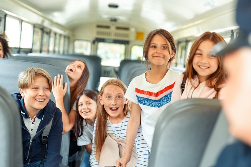 Schülerinnen und Schüler sitzen im Bus