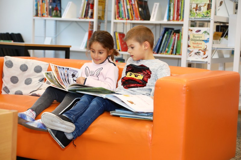 Zwei Kinder lesen in der Schulbibliothek