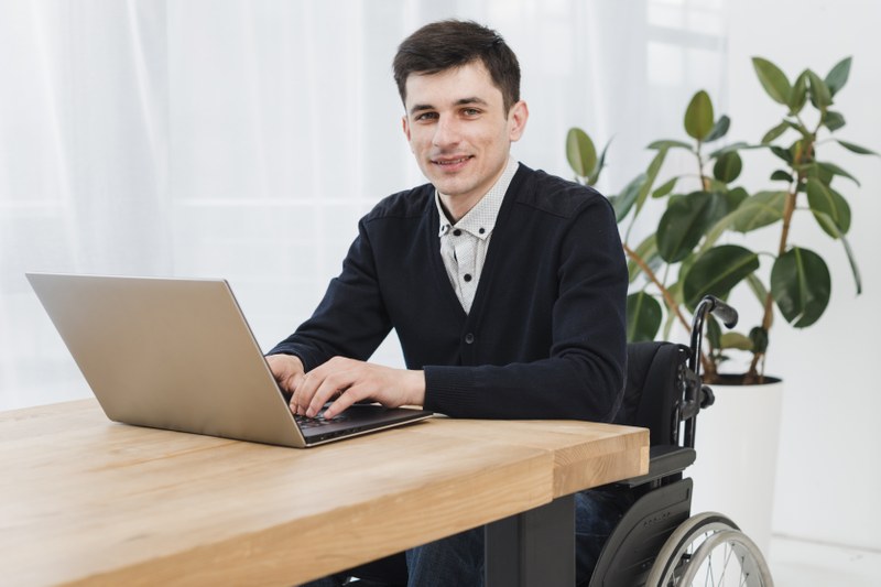 Mitarbeiter im Rollstuhl am Laptop
