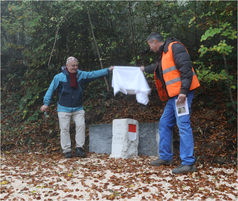 Der eingebaute Grenzstein im Wald, ein weisses Tuch wird abgehoben.