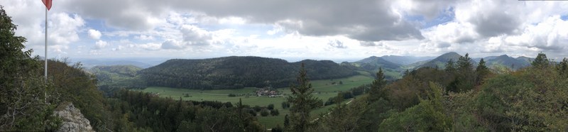 Panoramabild mit bewölktem Himmel, unten im Tal ist Bärenwil sichtbar.