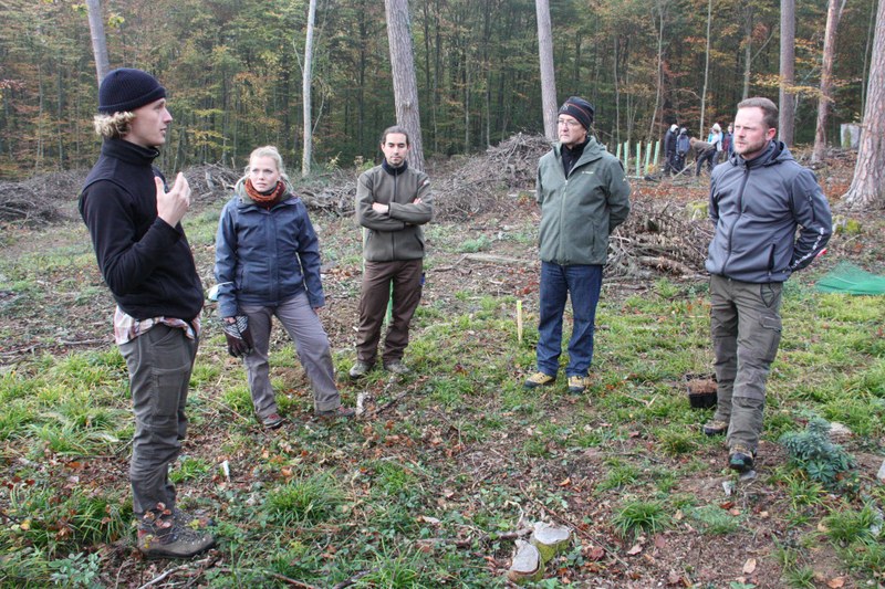 Projektleiter Jannis Schwärzli (l.) erklärt Thomas Weber (2.v.r.) und Samuel Bürgin (r.) wie wirkungsvoll es für die Jugendlichen ist, an einer Arbeit beteiligt zu sein, die über Generationen wirken wird.